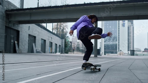 Sporty skater making trick on board outdoor. Skateboard rolling on asphalt.  photo