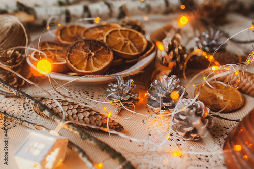 Christmas New Year top view of handmade crafts with pine cones, dry round slices of oranges, garland, branches. New year holiday, celebration concept. Flatlay