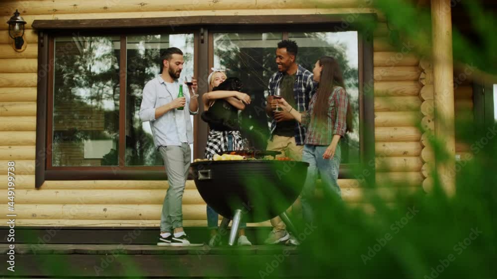 Playful fellows having fun with dog outside. Man giving wine for woman outdoors Playful fellows having fun with dog outside. Man giving wine for woman outdoors