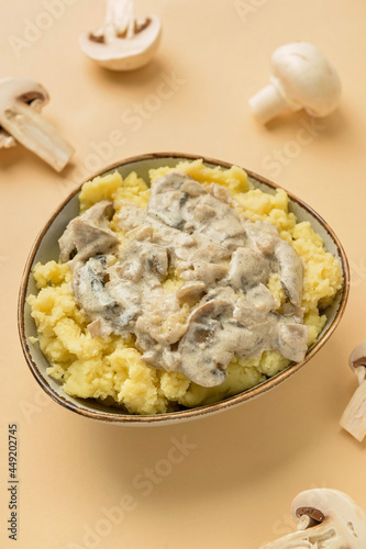 Bowl with tasty mashed potatoes and mushrooms on color background