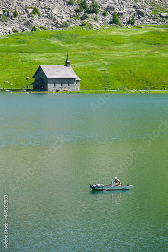 fisher in row boat at Melchsee with chapel photo