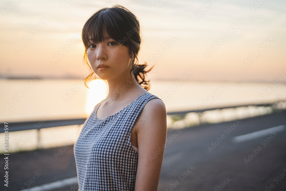 夕暮れの海にいる女性