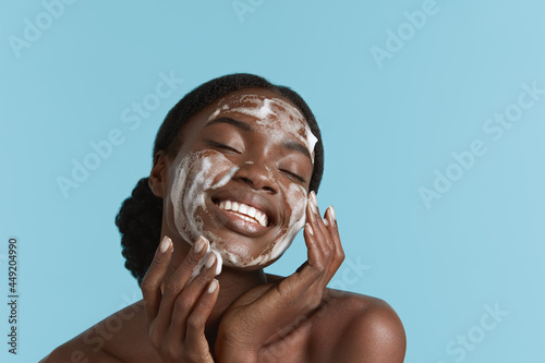 Photo Close up portrait of beautiful black girl wash her face with cleansing face foam