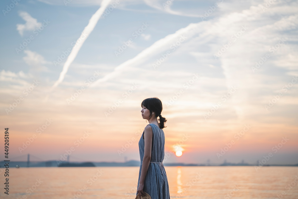 夕暮れの海にいる女性