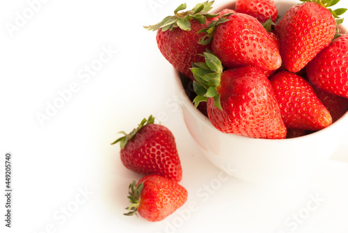 Red strawberries in a white cup isolated on white background
