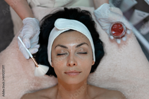 Women makes a rejuvenating brightening toning and nourishing mask at a beautician in a beauty salon
