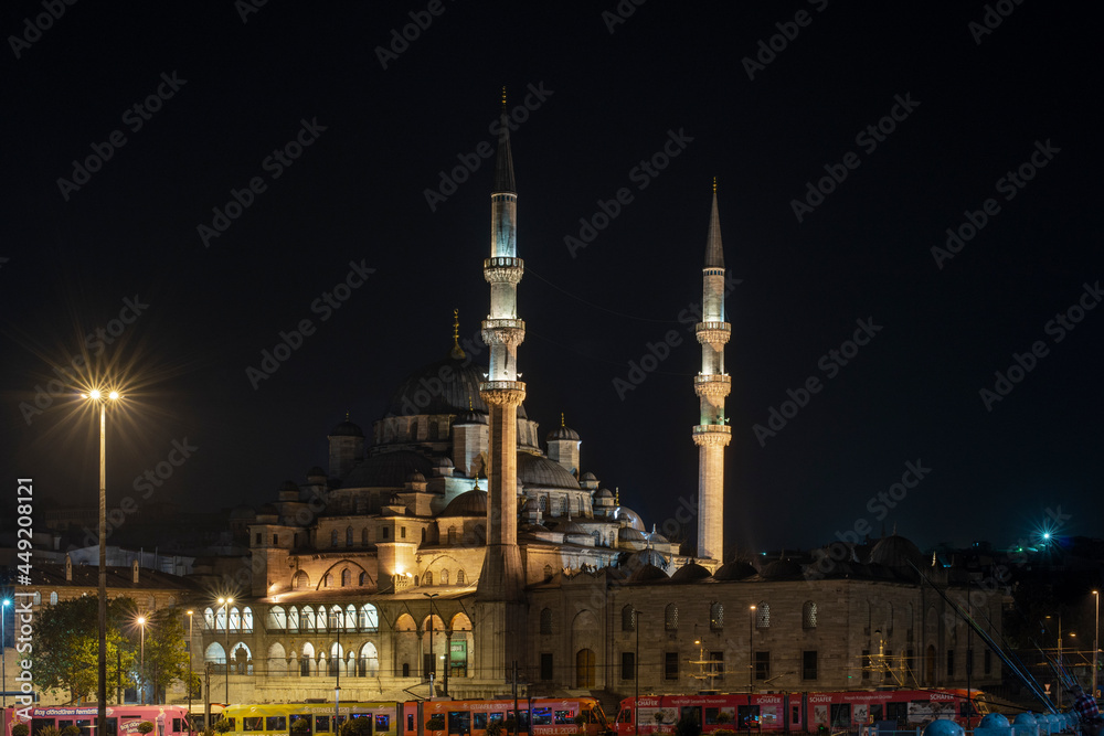 Night and long exposure image of the new Muslim Eminonu Mosque in the Golden Horn of Istanbul with the metro passing underneath and the photo taken from the Galata Bridge