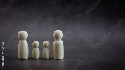 Wooden person family model on black background, Leadership concept. copy space