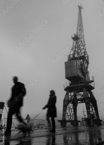 Obraz na plátně blurred, silhouetted figures walking in bristol docks