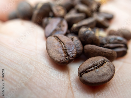 selective focus brown coffee beans macro in the hands of a coffee worker Photo close up of roasted coffee beans