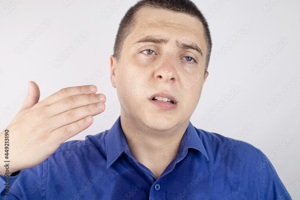 An office worker in a blue shirt looks at the camera. He covered in sweat stains. The man has a lot of stress, accompanied by increased sweating. The businessman is nervous and sweats a lot. An office worker in a blue shirt looks at the camera. He covered in sweat stains. The man has a lot of stress, accompanied by increased sweating. The businessman is nervous and sweats a lot.