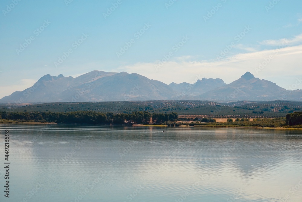 Panoramic view of the Granada reservoir of Cubillas (Spain) with the mountains in the background (Sierra Harana) and their reflection in the water