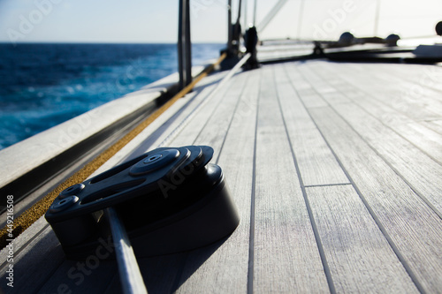 Part of the teak deck of a sailing yacht with fasteners on it for fixing ropes.