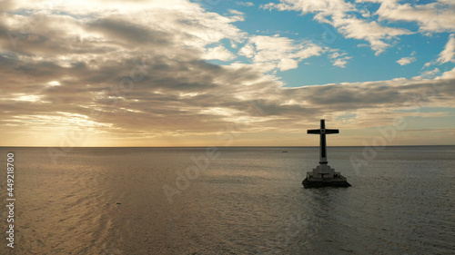Catholic cross in sunken cemetery in the sea at sunset, aerial view. Sunset at Sunken Cemetery Camiguin Island Philippines.