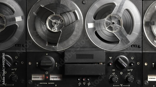 Vintage tape recorder roller. Reel film tape is rotating at a oldschool professional player. Concept of spying and recording a phone conversations. Inscription in Russian: recording control