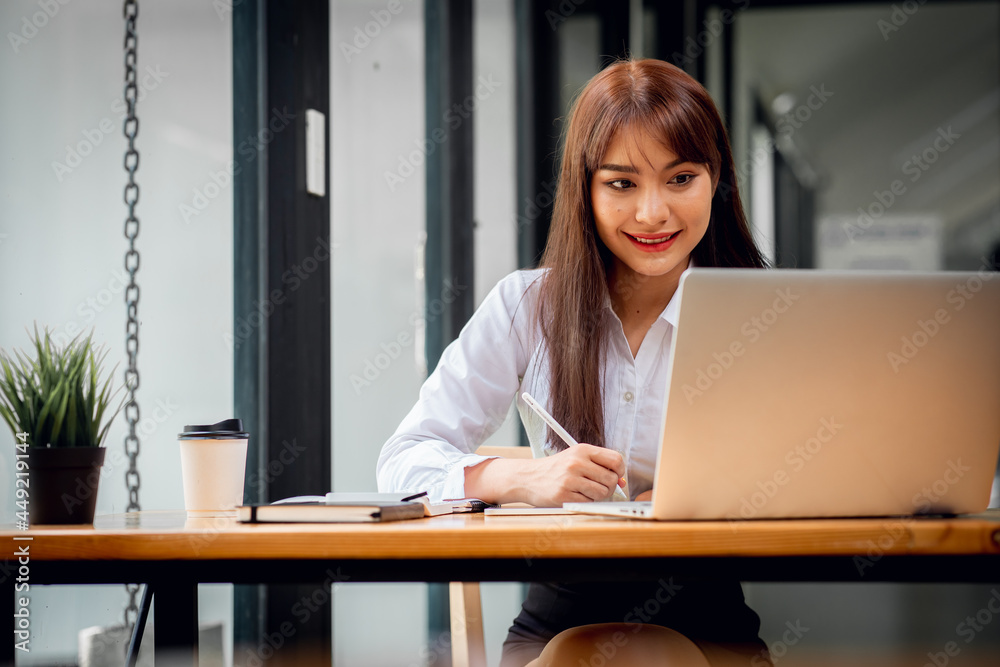Asian happy Young beautiful businesswoman sitting in workplace, doing finances,accounting analysis,report,data and pointing graph. Asian happy Young beautiful businesswoman sitting in workplace, doing finances,accounting analysis,report,data and pointing graph.
