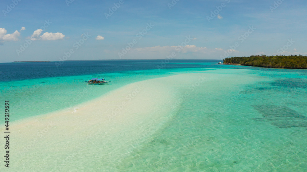 Sand bar and tropical island in the clear turquoise waters of the lagoon and atoll with a coral reef. Mansalangan sandbar, Balabac, Palawan, Philippines. Summer and travel vacation concept