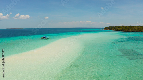 Sand bar and tropical island in the clear turquoise waters of the lagoon and atoll with a coral reef. Mansalangan sandbar, Balabac, Palawan, Philippines. Summer and travel vacation concept