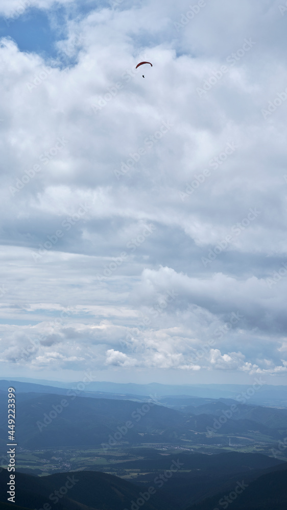 Paraglider high above the ground in the clouds Paraglider high above the ground in the clouds