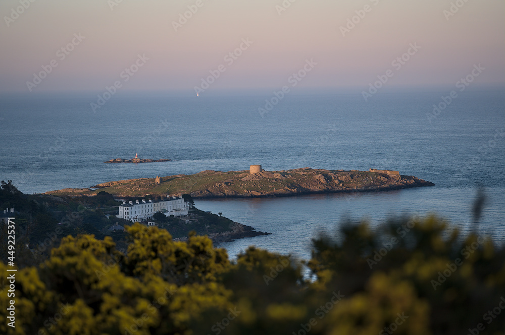 Beautiful evening view of Sorrento Point, Dalkey Island and Muglins Lighthouse from Killiney Hill during golden hour, Dublin, Ireland. Soft and selective focus