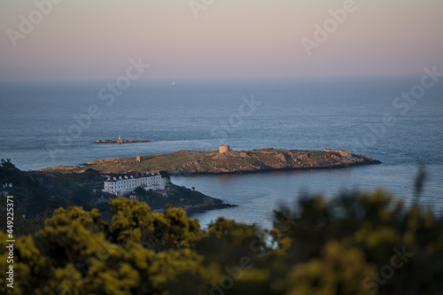 Beautiful evening view of Sorrento Point, Dalkey Island and Muglins Lighthouse from Killiney Hill during golden hour, Dublin, Ireland. Soft and selective focus photo