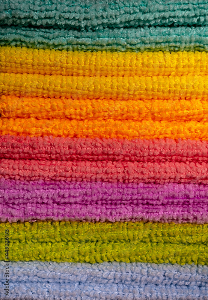 A stack of colored microfiber napkins. Row of vertical colorful microfiber towels. Full frame A stack of colored microfiber napkins. Row of vertical colorful microfiber towels. Full frame
