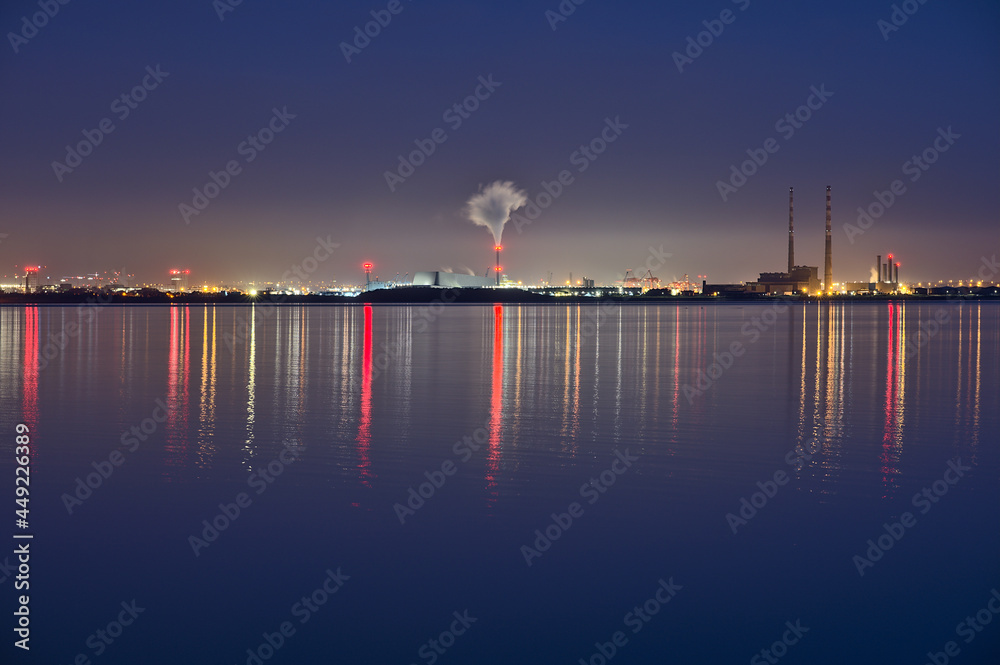 Obraz premium Spectacular early morning view of Dublin Waste to Energy (Covanta Plant), Poolbeg CCGT and Pigeon House Power Station view from Dun Laoghaire Harbor with light reflection in water, Dublin, Ireland