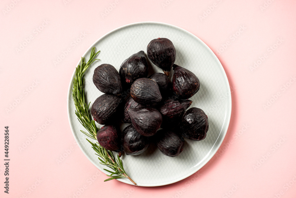 Fresh ripe figs in a plate. Beautiful blue violet fruit on pastel pink background. Healthy Mediterranean fig fruit. Copy space for text. Top view. Vegan concept Fresh ripe figs in a plate. Beautiful blue violet fruit on pastel pink background. Healthy Mediterranean fig fruit. Copy space for text. Top view. Vegan concept
