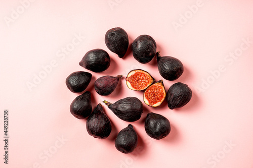 Fresh ripe figs in a plate. Beautiful blue violet fruit on pastel pink background. Healthy Mediterranean fig fruit. Copy space for text. Top view. Vegan concept