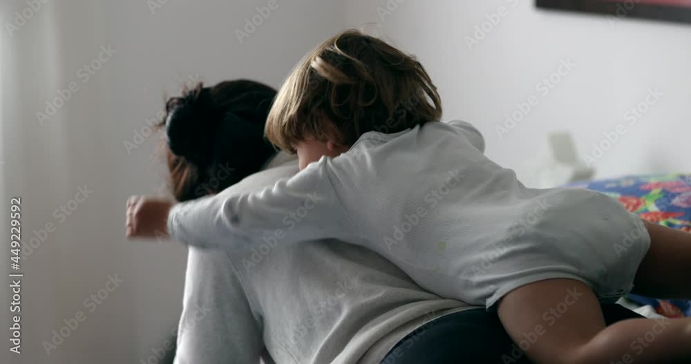 Toddler jumping into mother back. playful child boy