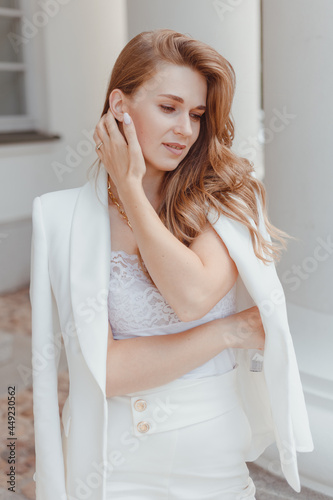 Elegant young woman in while fashion look outdoors