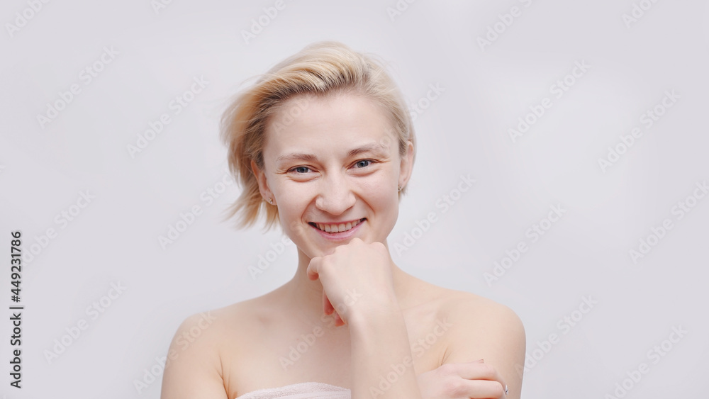 A beautiful blonde topless model with short hair posing for the camera. Hand on her chin smiling. Isolated girl over white background studio shot. Beauty concept. A beautiful blonde topless model with short hair posing for the camera. Hand on her chin smiling. Isolated girl over white background studio shot. Beauty concept.