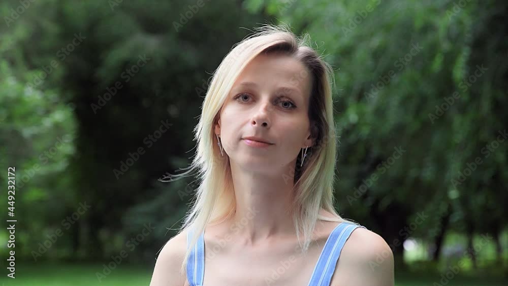A beautiful woman in nature smiles and looks at the camera A beautiful woman in nature smiles and looks at the camera