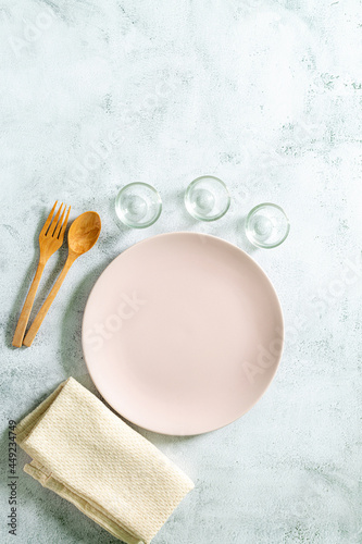 Ceramic plate with cutlery on white surface.,Empty white plate on gray concrete stone background. Top view, copy space
