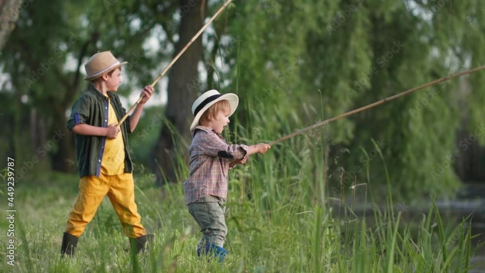 outdoor activities, healthy boys in straw hats have fun fishing with wooden rods in river during summer holidays outside city in village outdoor activities, healthy boys in straw hats have fun fishing with wooden rods in river during summer holidays outside city in village