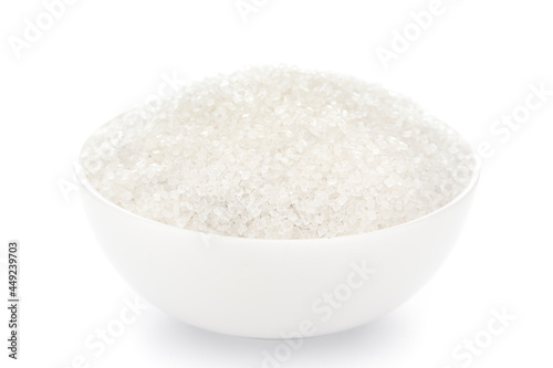 Close-Up of white crystal of sugar (fructose-sucrose) in white ceramic bowl over white background