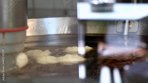 Close up of press machine making lokma fried dough, traditional Greek sweet food.  photo