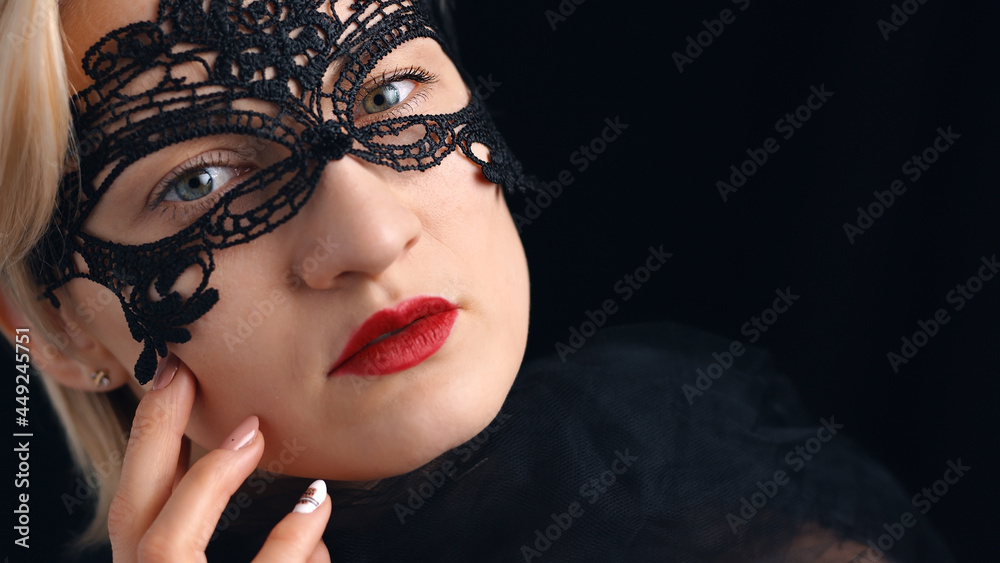 Fototapeta premium Model wearing A Masquerade Mask and red lipstick. Closeup headshot. Mysterious girl wearing a Venetian Masquerade mask. Concept of masquerade ball costume party. Isolated shot. 