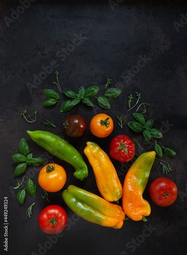 Close-up photo of fresh farm organic vegetables and greenery. Top view on dark concrete background