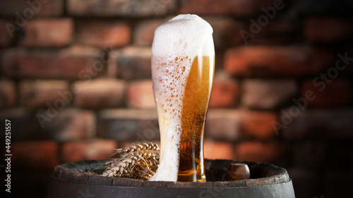 Foto Glass of beer with foam spilling over the edge.
