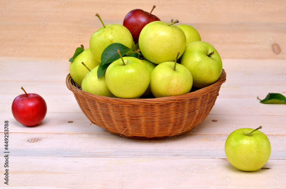 green and red apples in a wicker bowl on the table