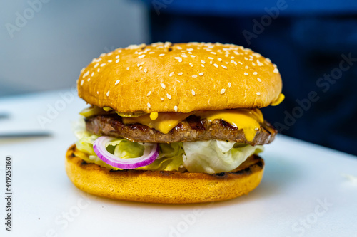 Full length view of the fresh burger with meat patty. Big appetizing burger with meat cutlet. Unhealthy food concept photo