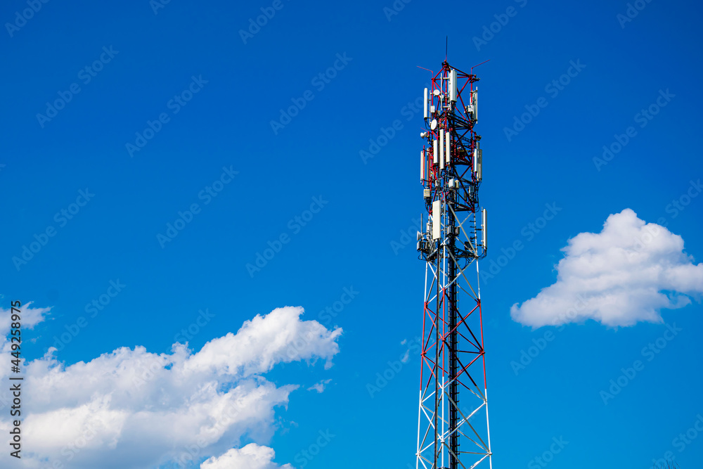 Telecommunication tower of 4G and 5G cellular. Macro Base Station. 5G radio network telecommunication equipment with radio modules and smart antennas mounted on a metal against cloulds sky background.