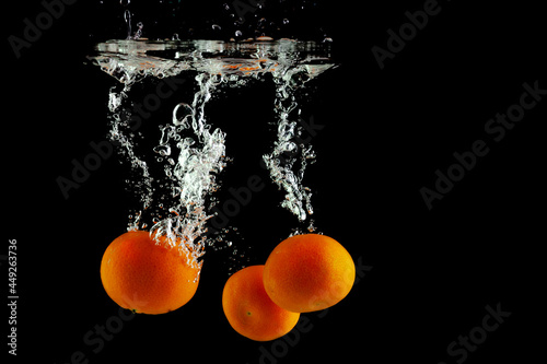 three fresh tangerines fell into the water with splashes