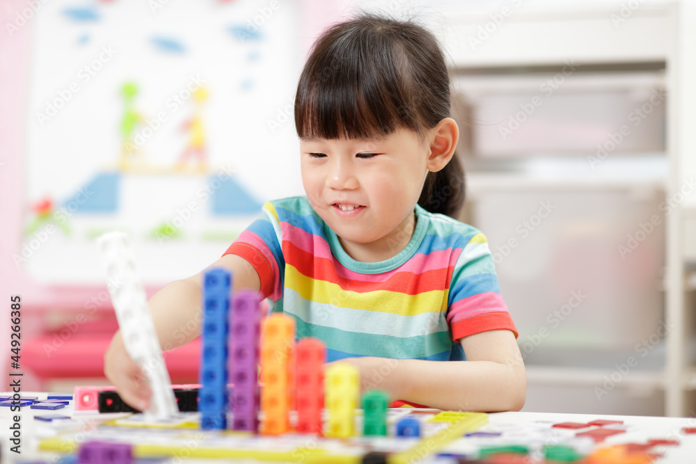 Fototapeta premium young girl play number blocks for homeschooling