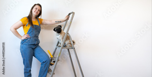 Foto Independent single woman makes repairs in her apartment with her pet