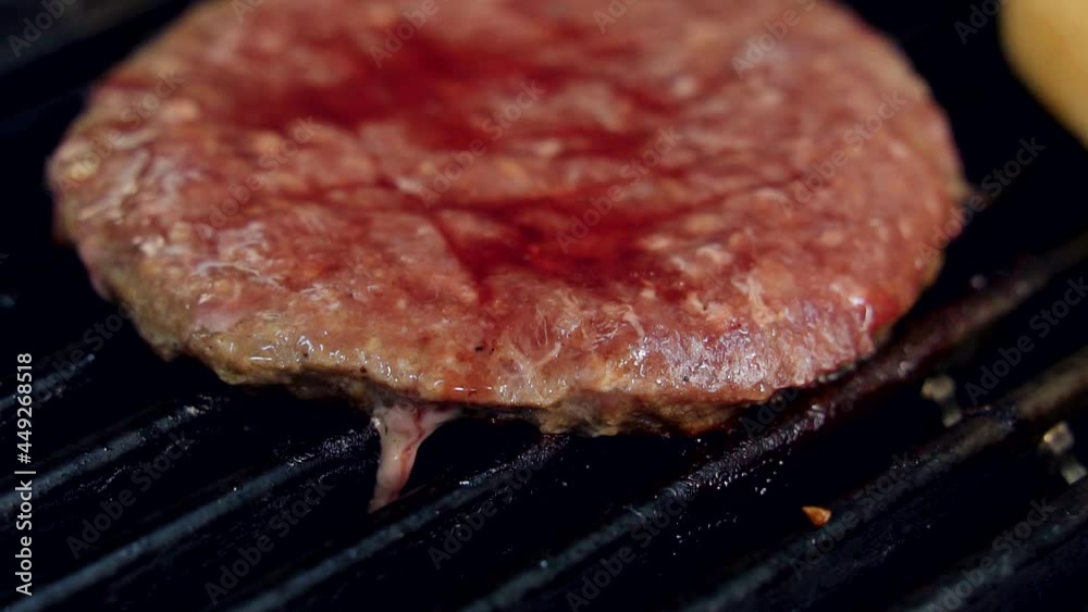 Frying raw cutlet. Meat cutlet is roasting on hot grill. Process of cooking beef cutlet for hamburger. Macro shot. Frying raw cutlet. Meat cutlet is roasting on hot grill. Process of cooking beef cutlet for hamburger. Macro shot.