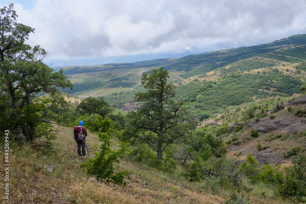 Girl in a mountain hike on the hillside. Crimean coast, the foot of Demerdzhi.