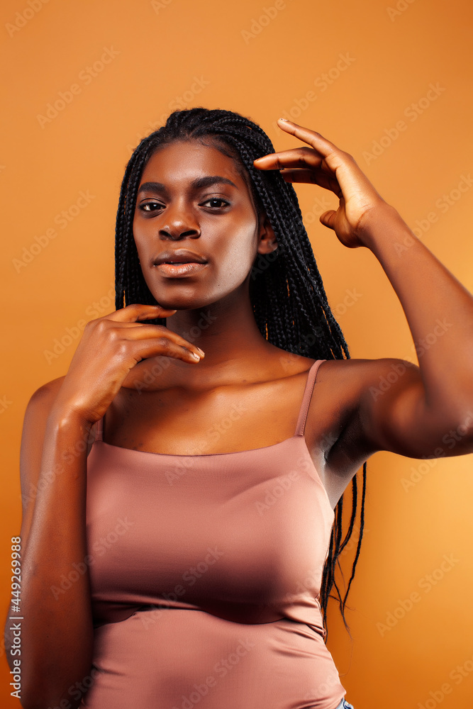 Fototapeta premium pretty young african american woman with braids posing cheerful gesturing on brown background, lifestyle people concept