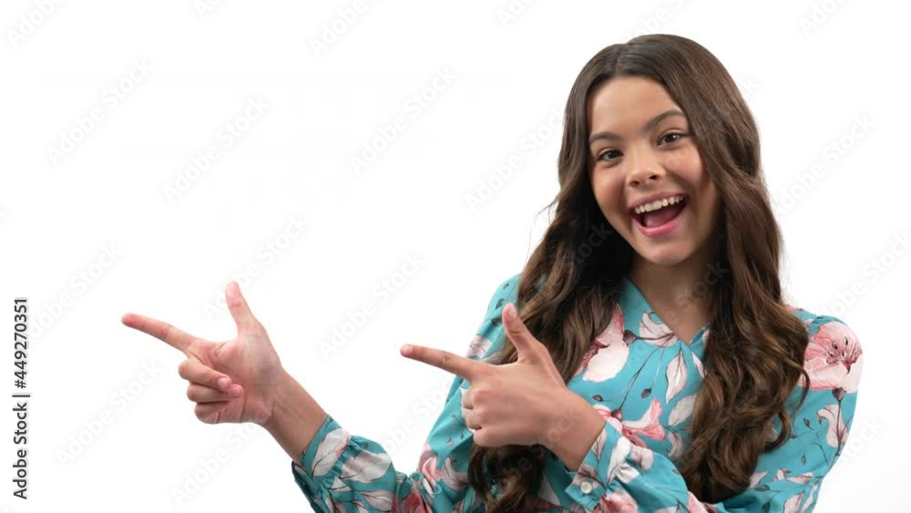 amazed looking kid curly hair pointing finger on copy space for advert isolated on white, advert